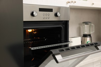 Photo of Open electric oven in kitchen. Cooking appliance