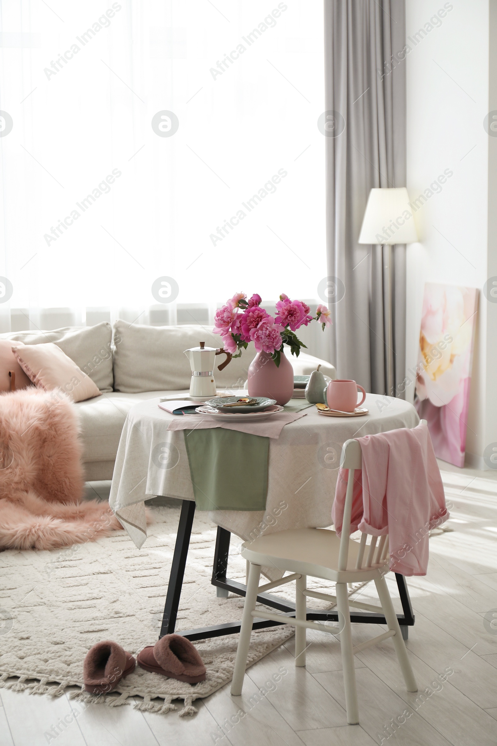 Photo of Beautiful table setting with pink peonies in living room