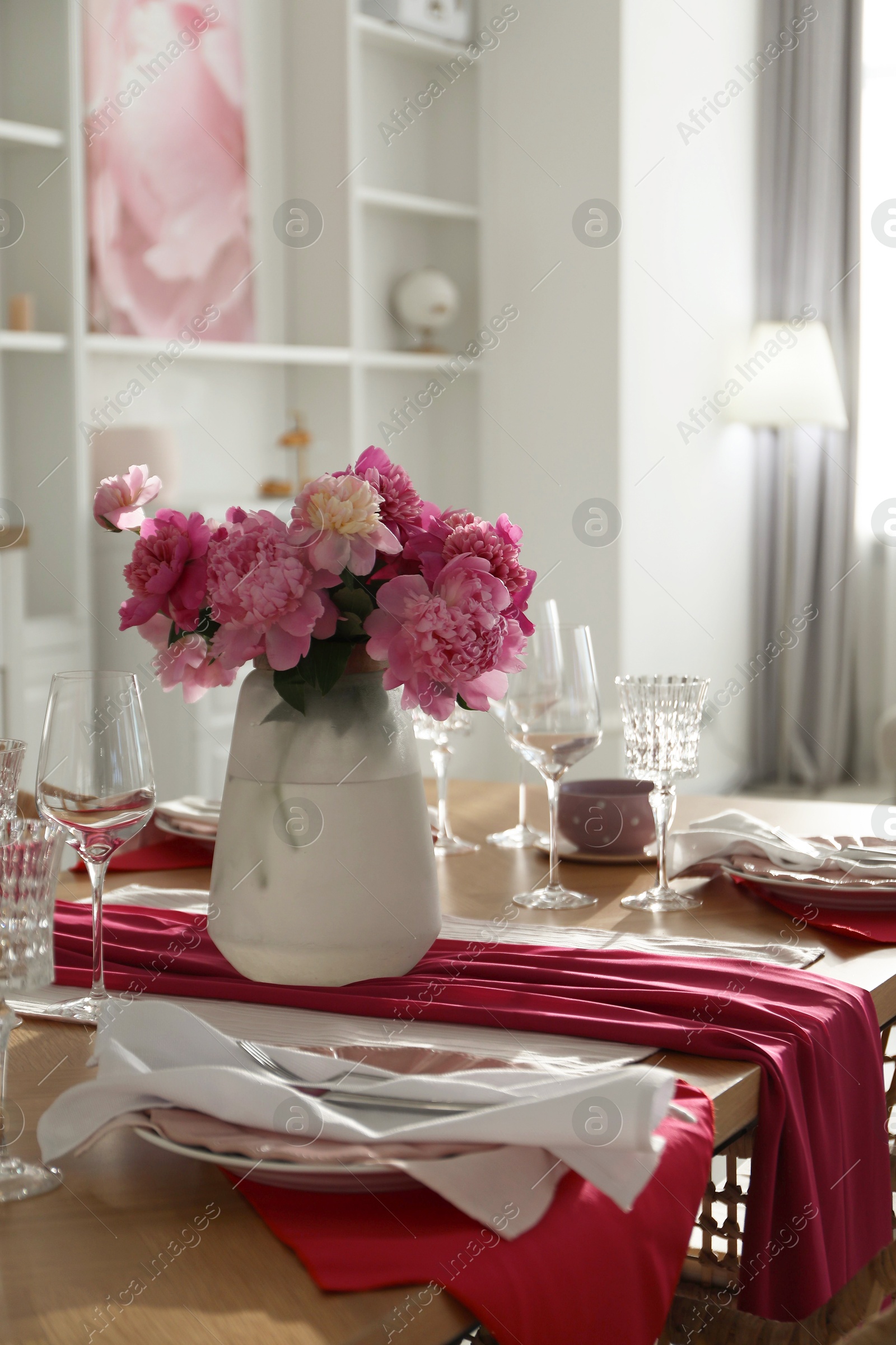 Photo of Beautiful table setting with pink peonies in dining room