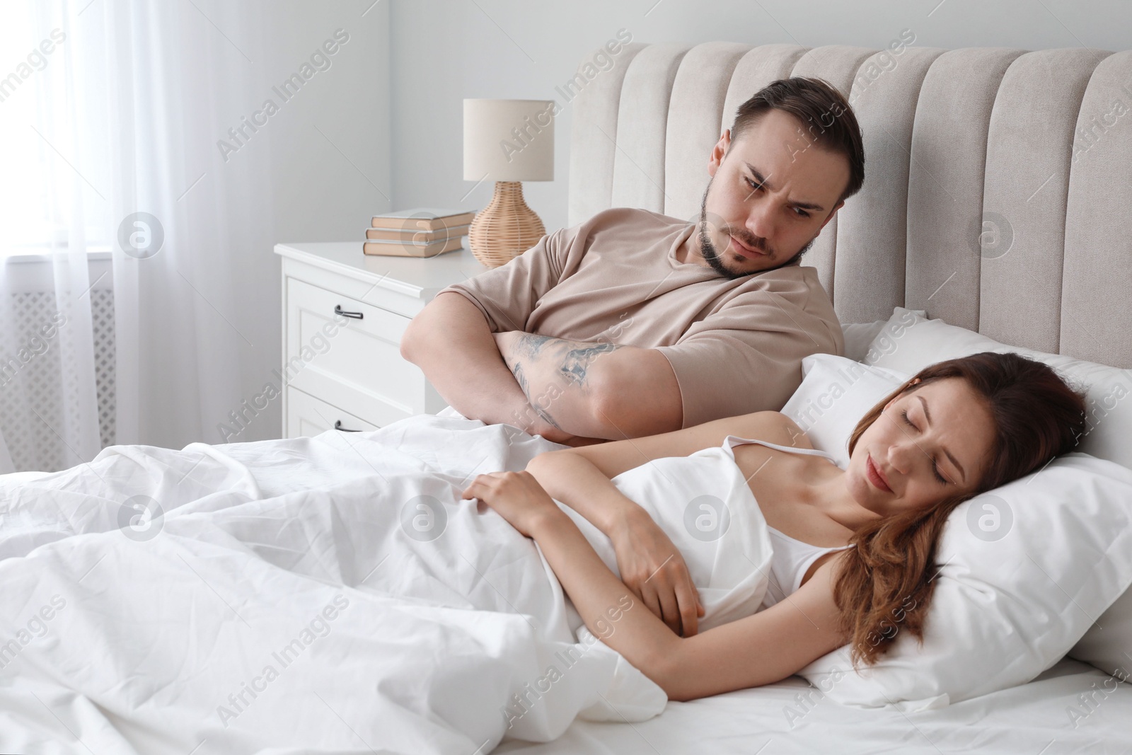 Photo of Offended couple after quarrel in bedroom. Relationship problem