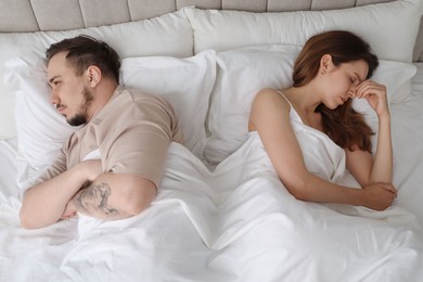 Photo of Offended couple after quarrel ignoring each other in bed. Relationship problem