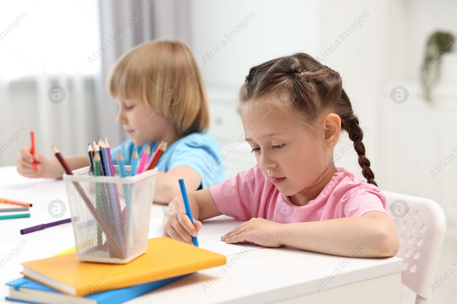 Photo of Cute little children drawing at table indoors