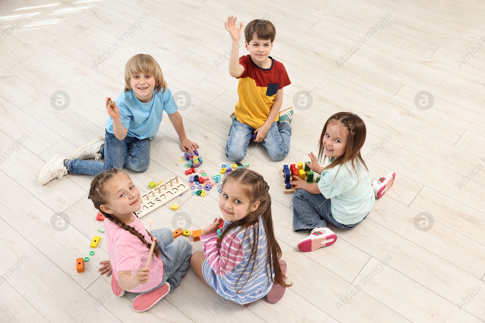 Photo of Group of children playing together on floor indoors