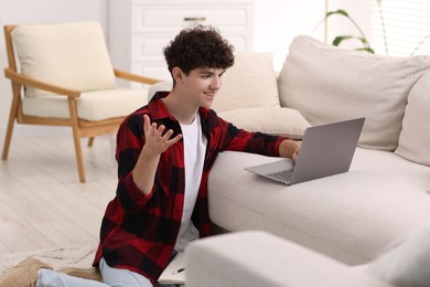 Photo of Teenager working with laptop at home. Remote job