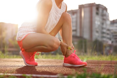 Photo of Sportswoman with injured leg at stadium, closeup