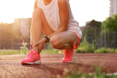 Sportswoman with injured leg at stadium, closeup