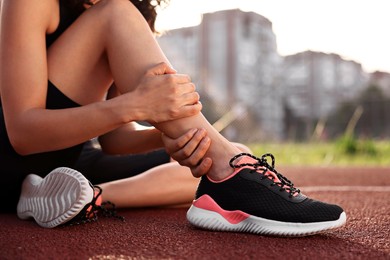 Sportswoman with injured leg at stadium, closeup