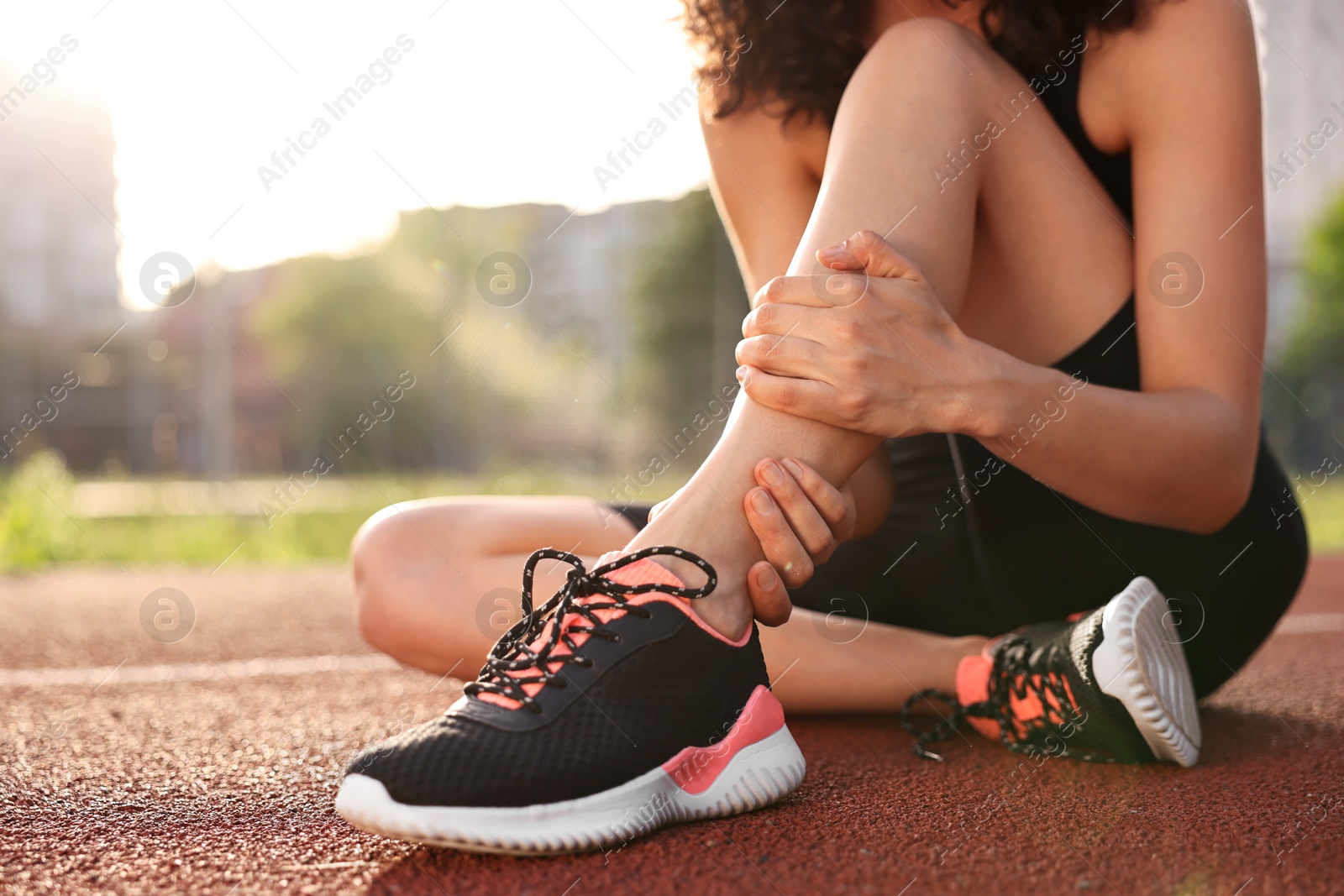 Photo of Sportswoman with injured leg at stadium, closeup