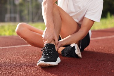 Photo of Sportsman with leg injury at stadium, closeup