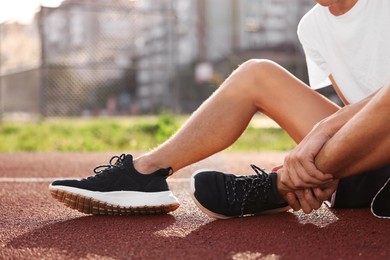 Sportsman with leg injury at stadium, closeup