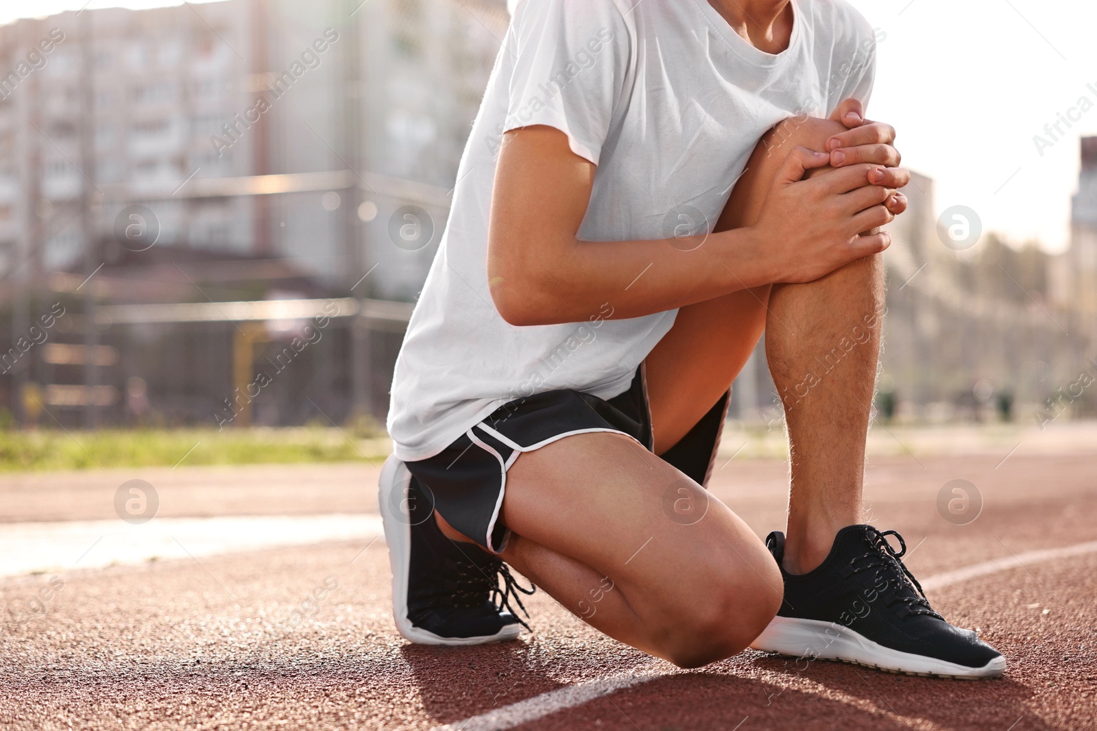 Photo of Sportsman with leg injury suffering from knee pain at stadium, closeup. Space for text