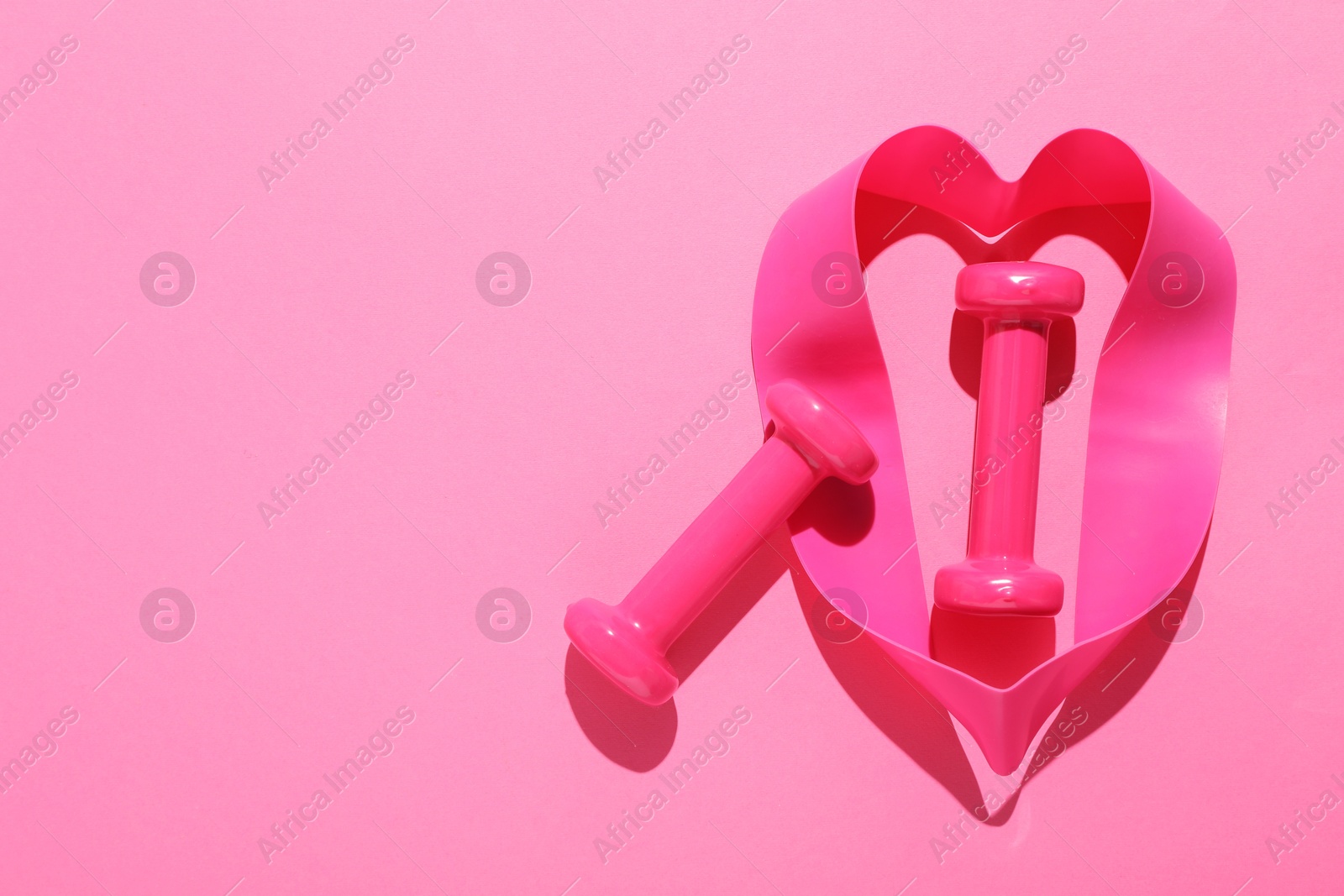 Photo of Dumbbells and fitness elastic band on pink background, flat lay. Space for text