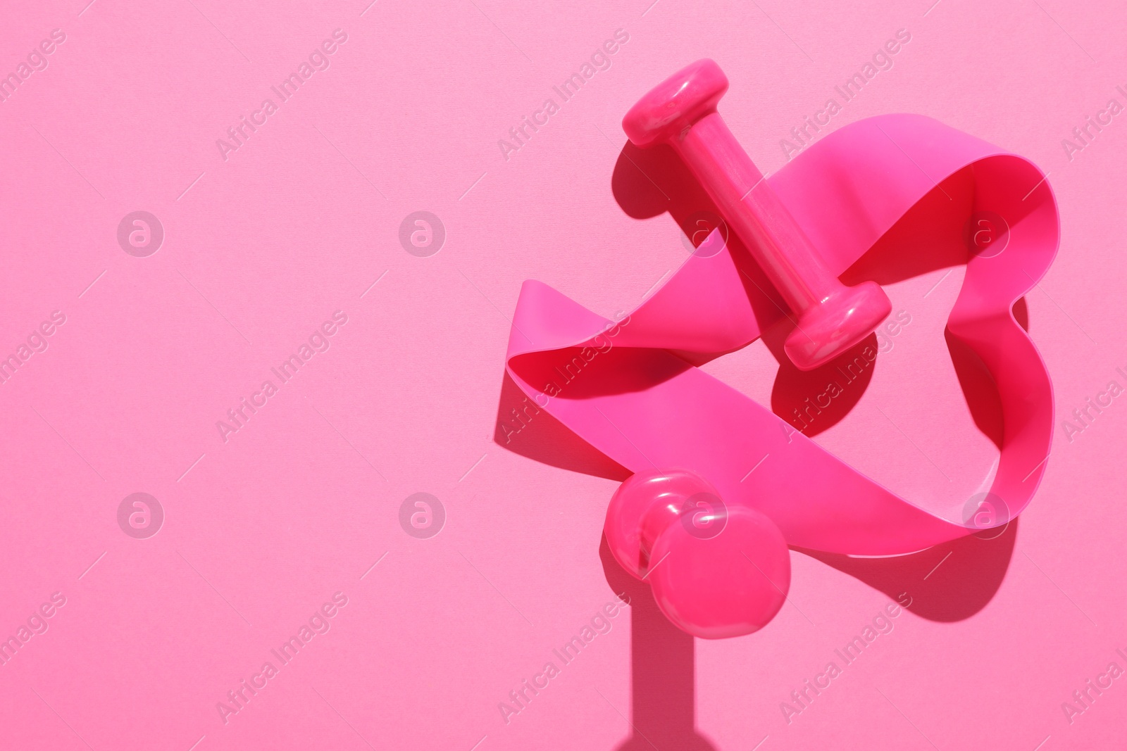 Photo of Dumbbells and fitness elastic band on pink background, flat lay. Space for text