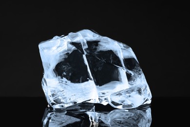 Photo of Piece of clear ice on black mirror surface