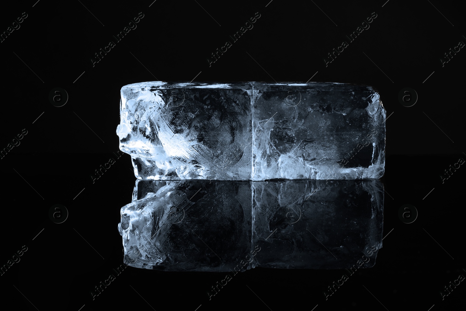 Photo of Blocks of clear ice on black mirror surface