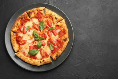 Photo of Delicious Margherita pizza on black table, top view. Space for text