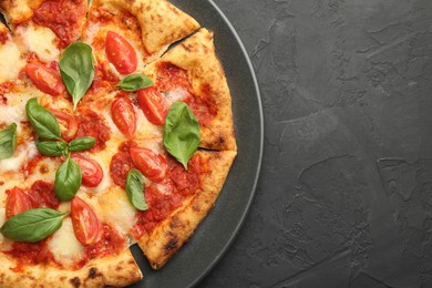 Photo of Delicious Margherita pizza on black table, top view. Space for text