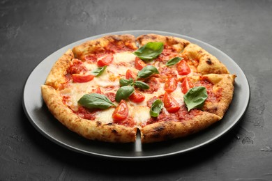 Photo of One delicious Margherita pizza on black table