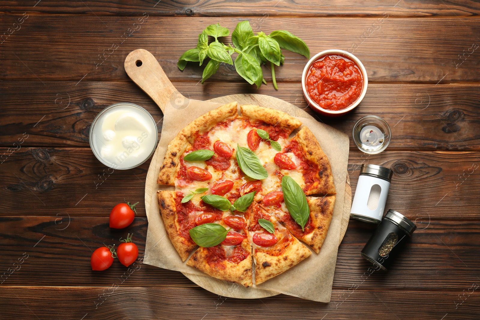 Photo of Delicious Margherita pizza and ingredients on wooden table, top view