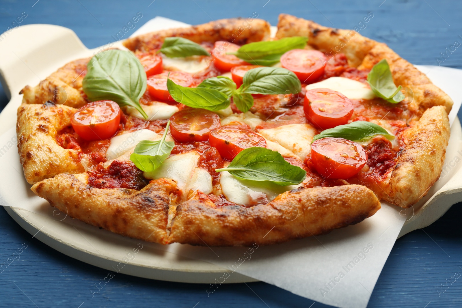 Photo of Delicious Margherita pizza on blue wooden table, closeup