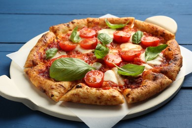 Photo of Delicious Margherita pizza on blue wooden table, closeup
