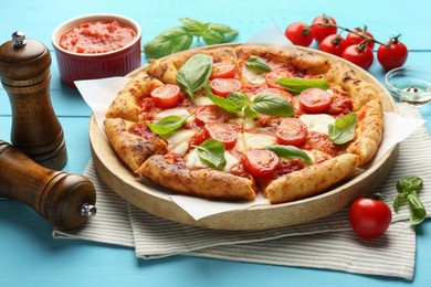 Photo of Delicious Margherita pizza and ingredients on light blue wooden table
