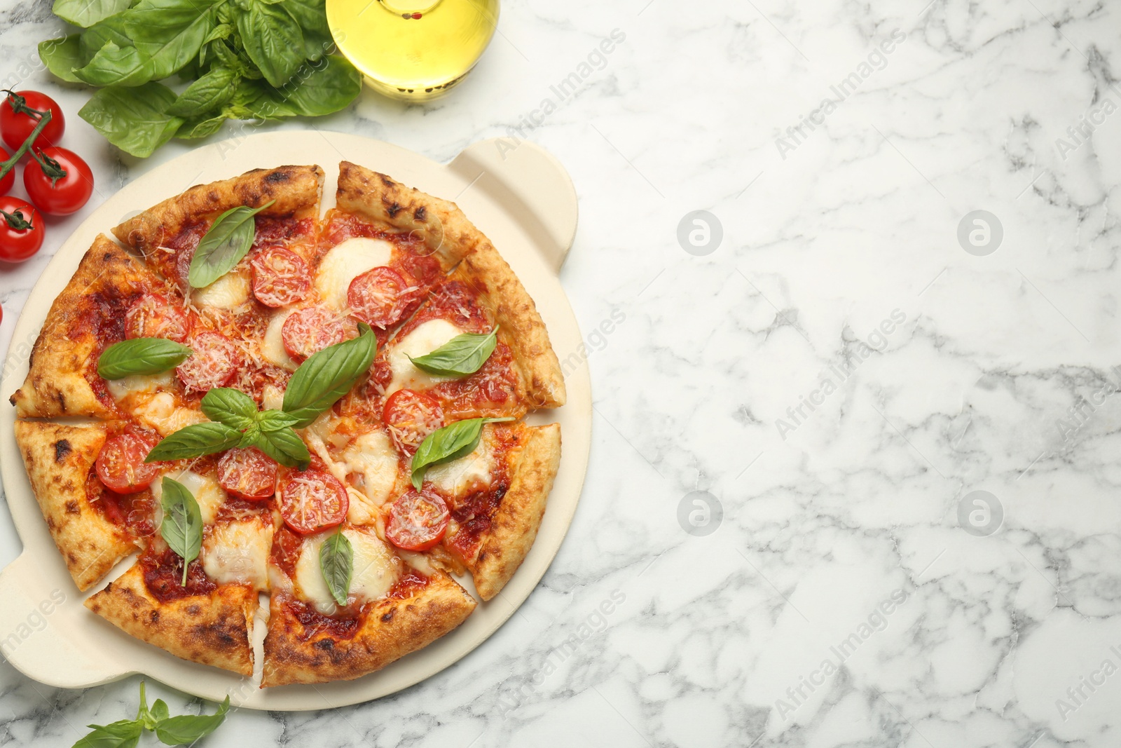 Photo of Delicious Margherita pizza and ingredients on white marble table, top view. Space for text