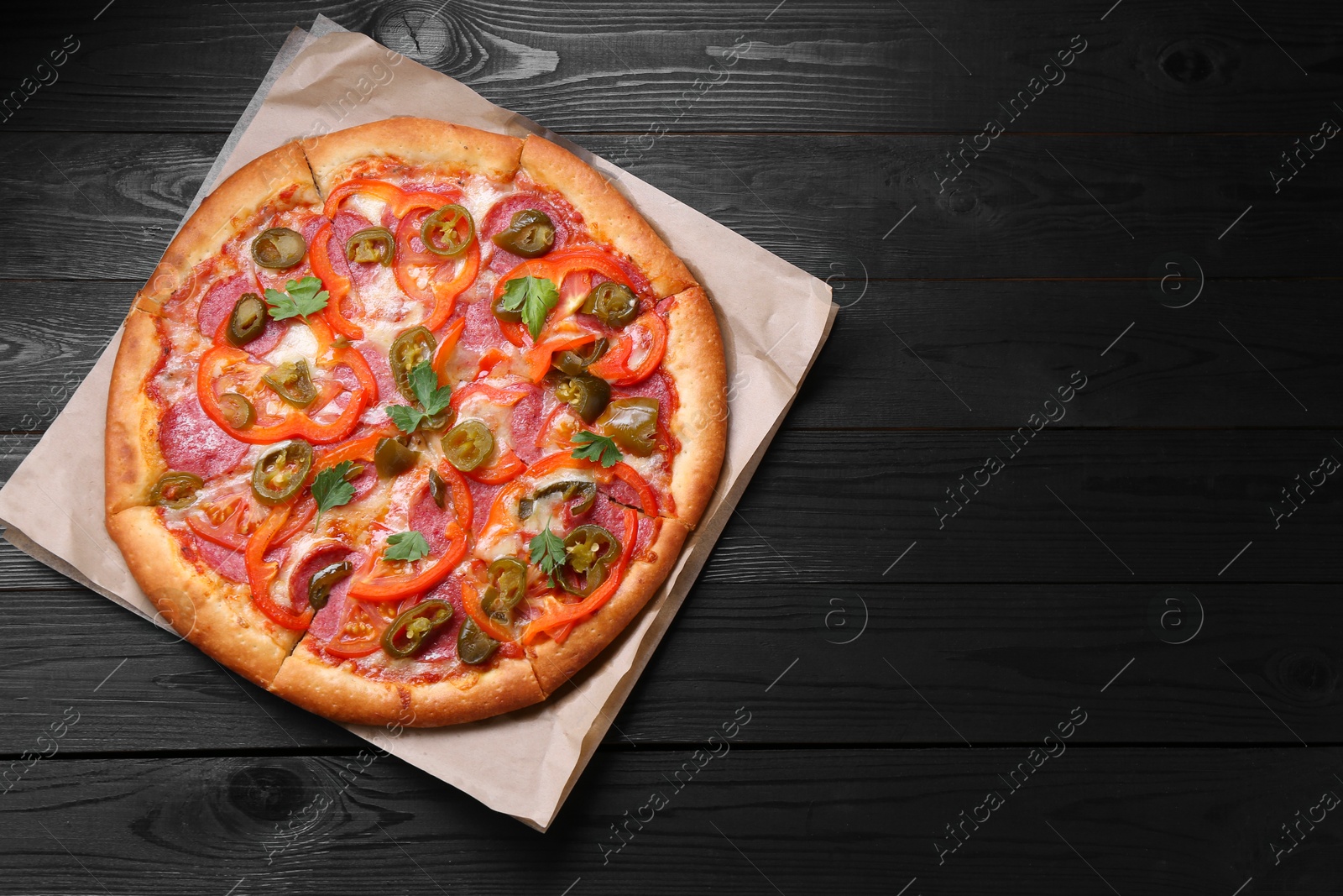 Photo of Delicious pizza Diablo on black wooden table, top view. Space for text