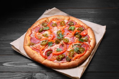 Photo of Delicious pizza Diablo on black wooden table