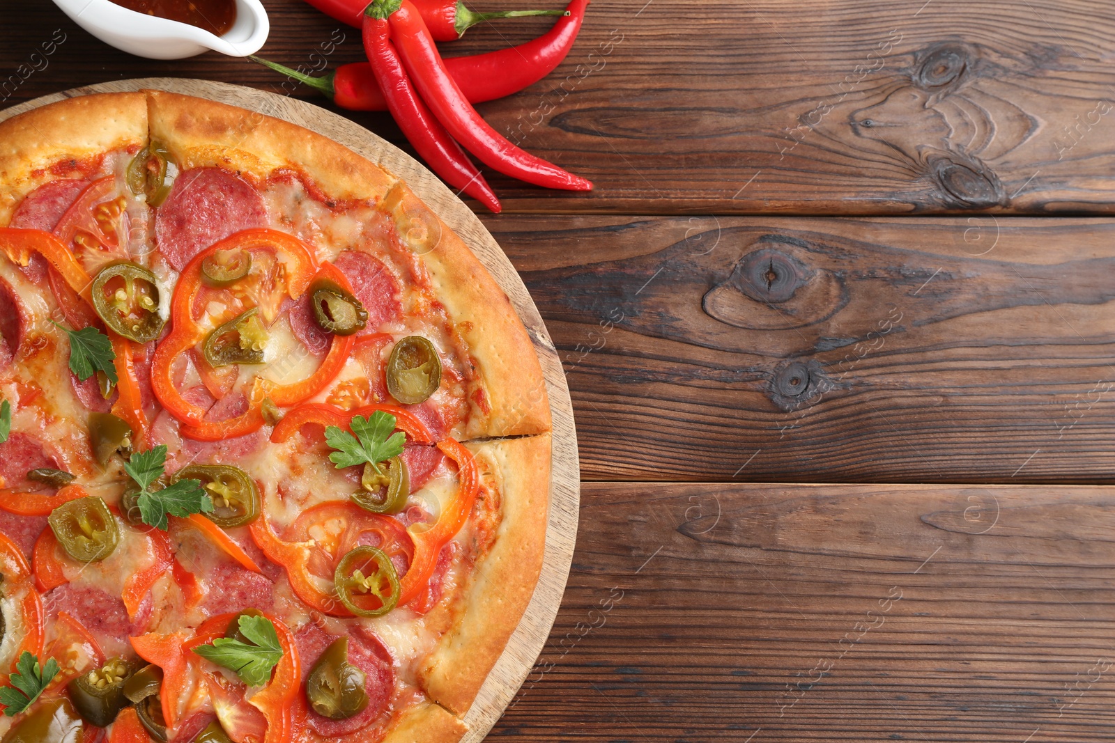 Photo of Delicious pizza Diablo served on wooden table, flat lay. Space for text