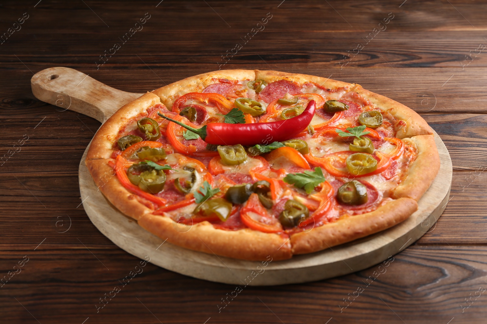 Photo of Delicious hot pizza Diablo on wooden table