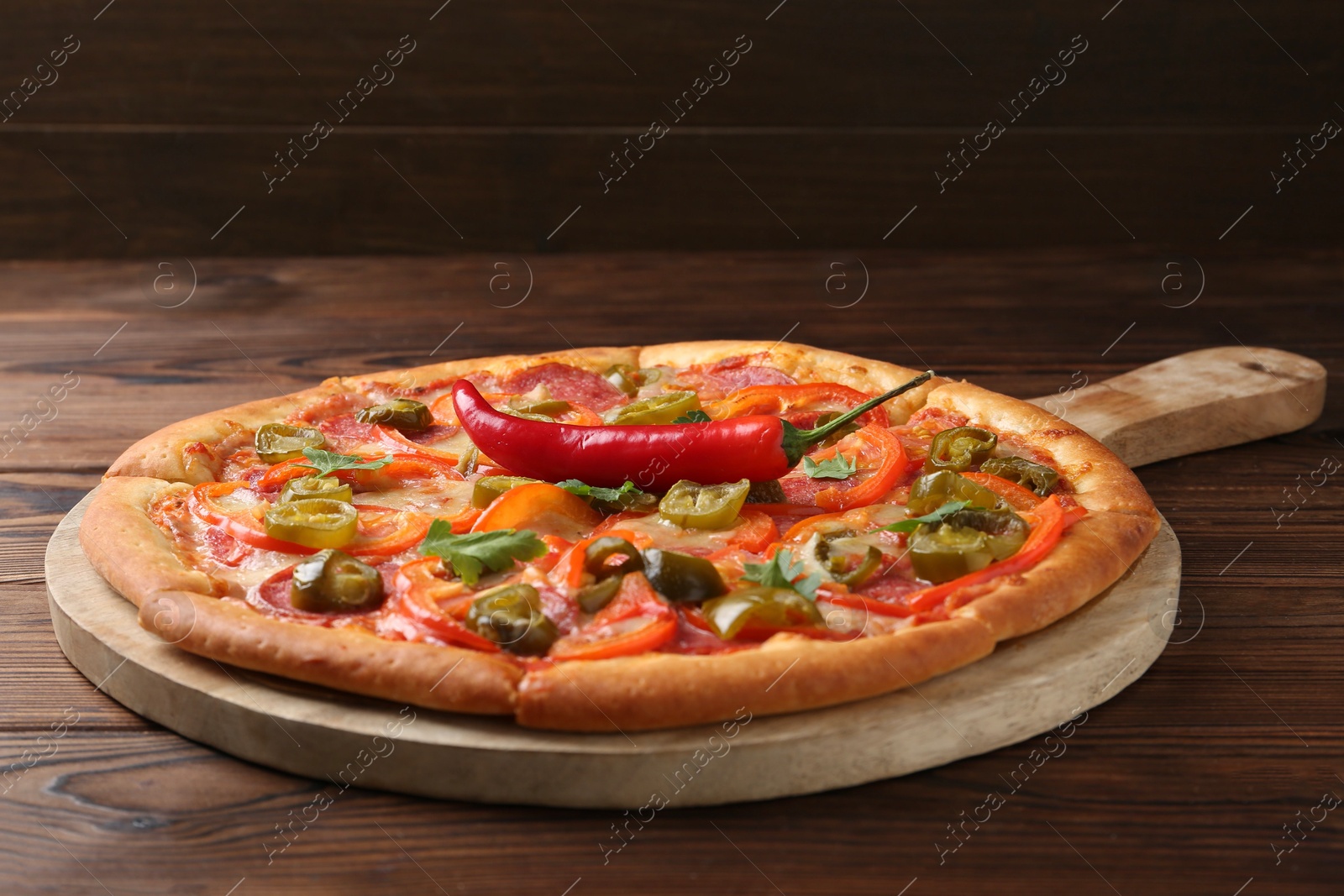 Photo of Delicious hot pizza Diablo on wooden table