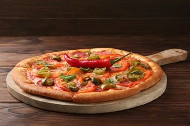 Photo of Delicious hot pizza Diablo on wooden table