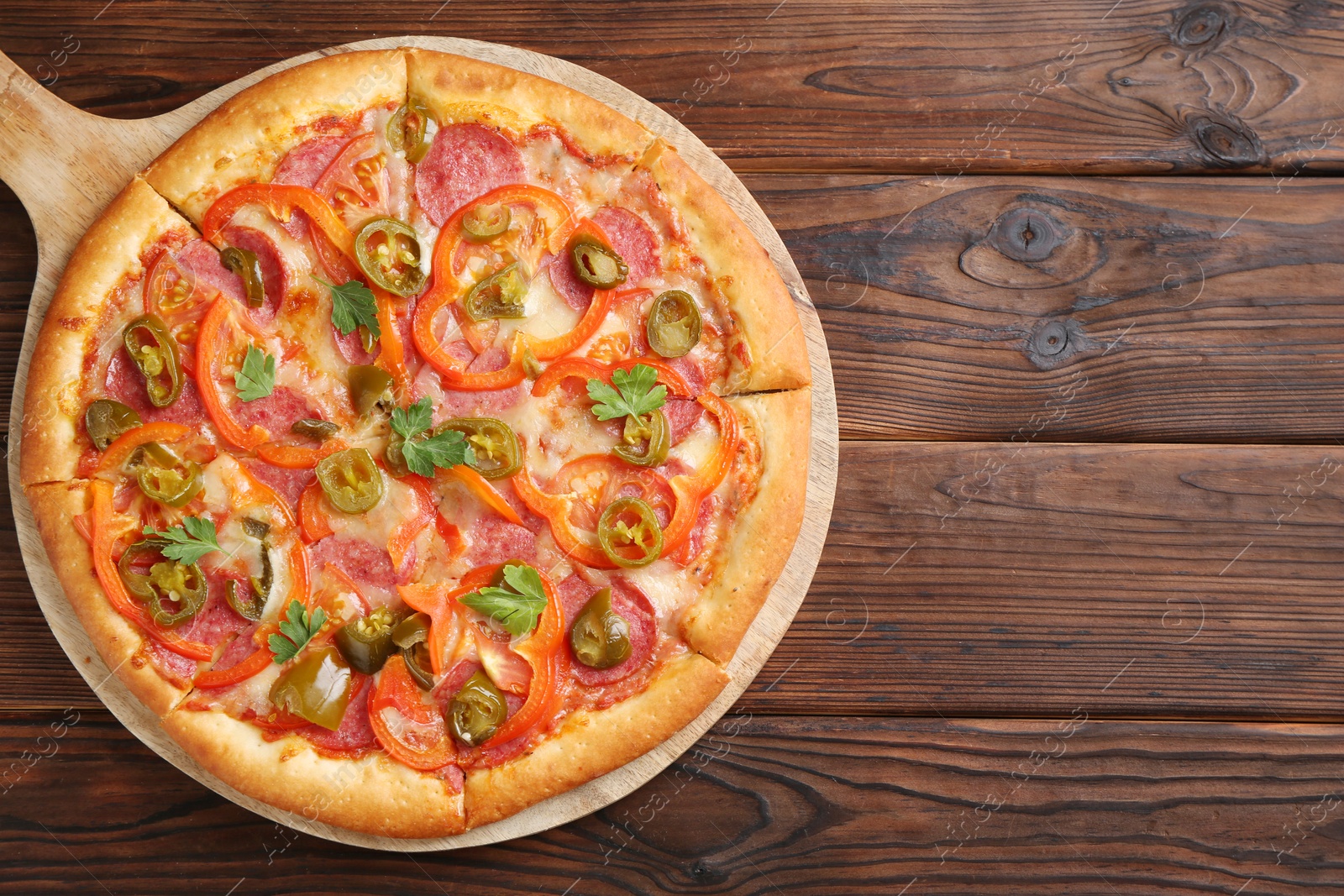 Photo of Delicious pizza Diablo on wooden table, top view. Space for text