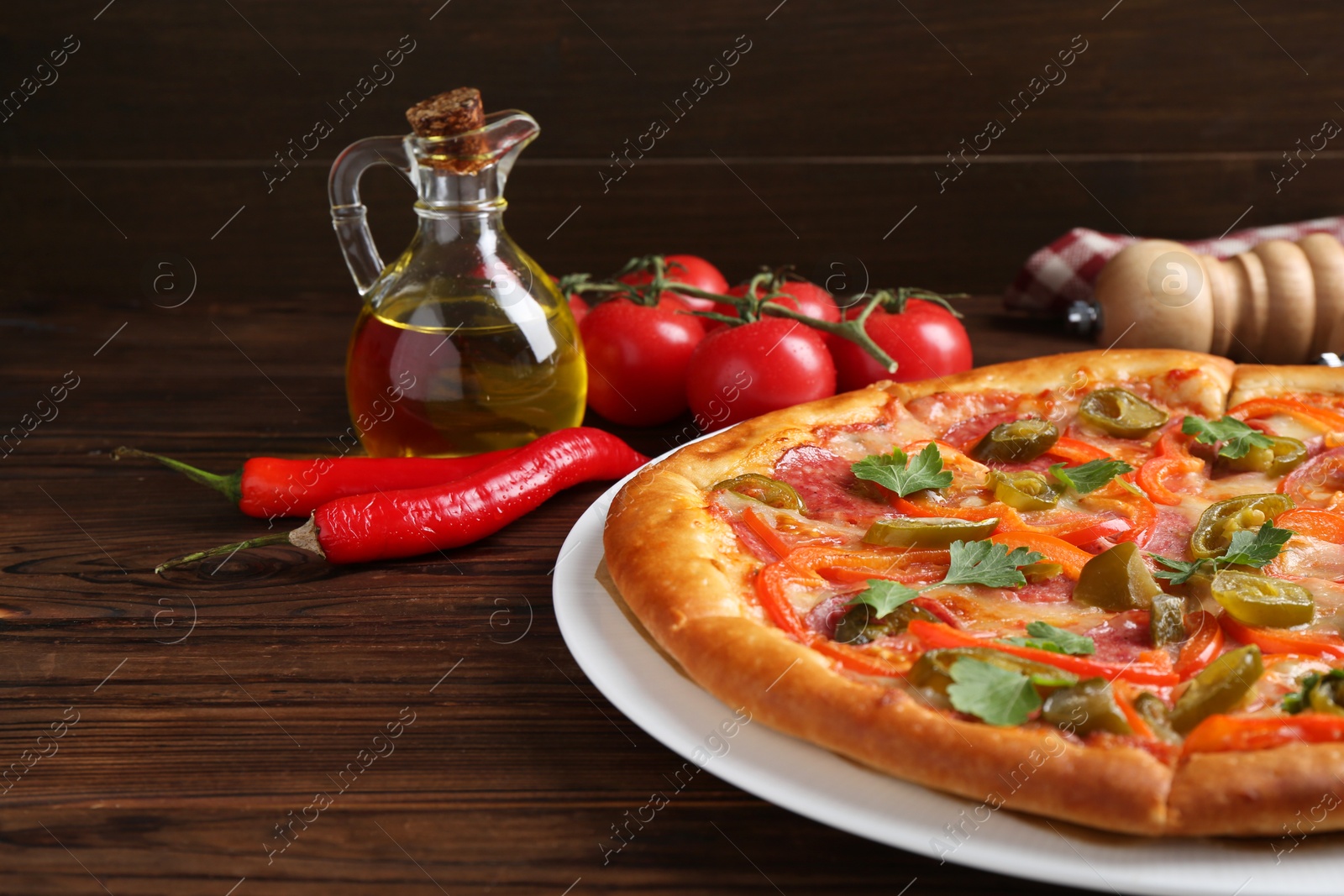 Photo of Delicious pizza Diablo and ingredients on wooden table, closeup. Space for text