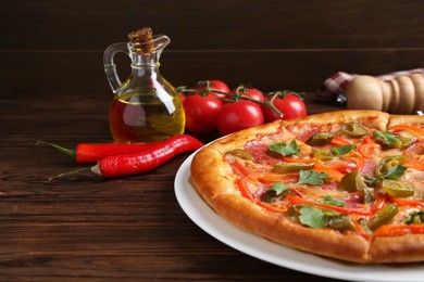 Photo of Delicious pizza Diablo and ingredients on wooden table, closeup. Space for text