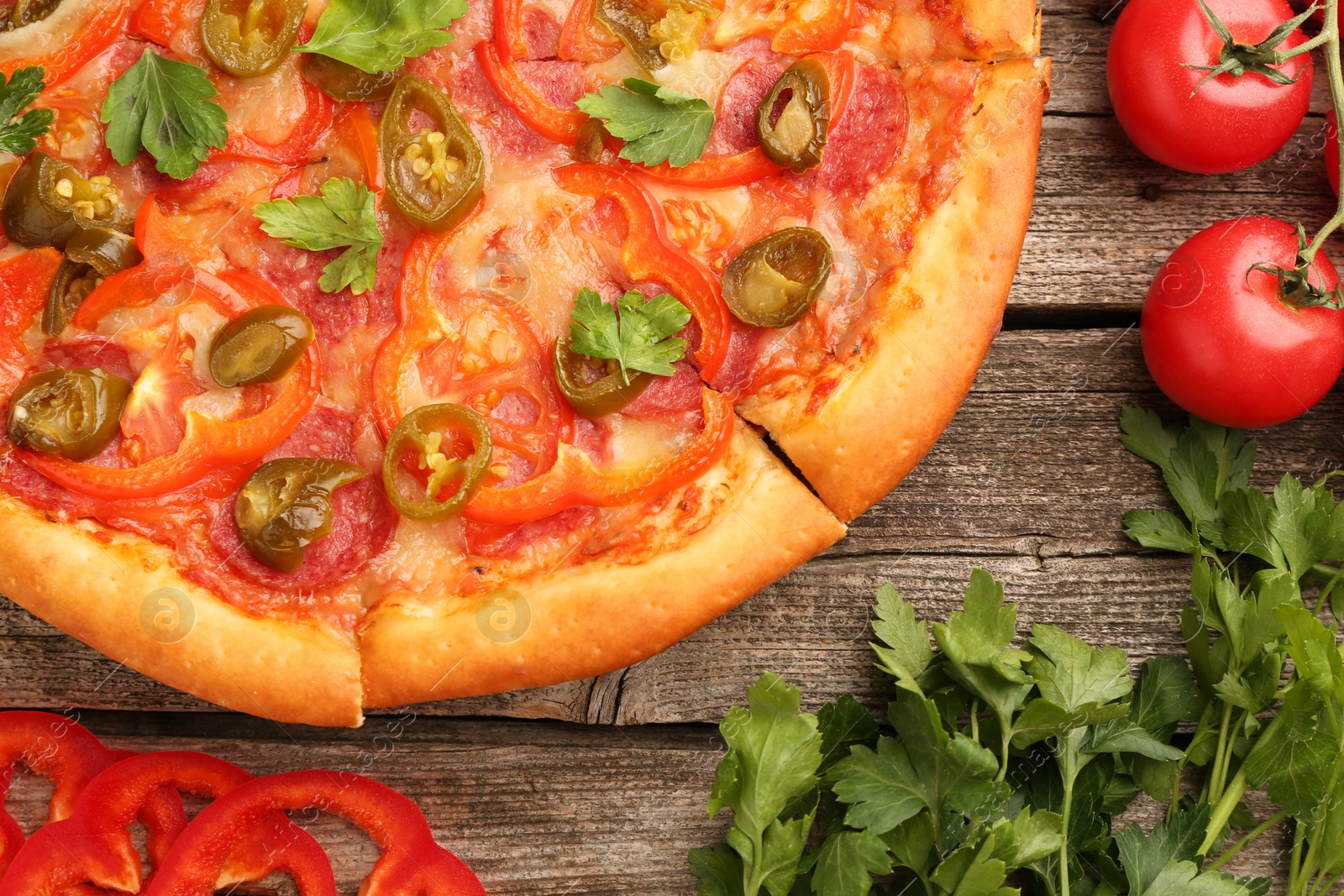 Photo of Delicious pizza Diablo and ingredients on wooden table, flat lay