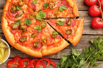 Photo of Delicious pizza Diablo and ingredients on wooden table, flat lay