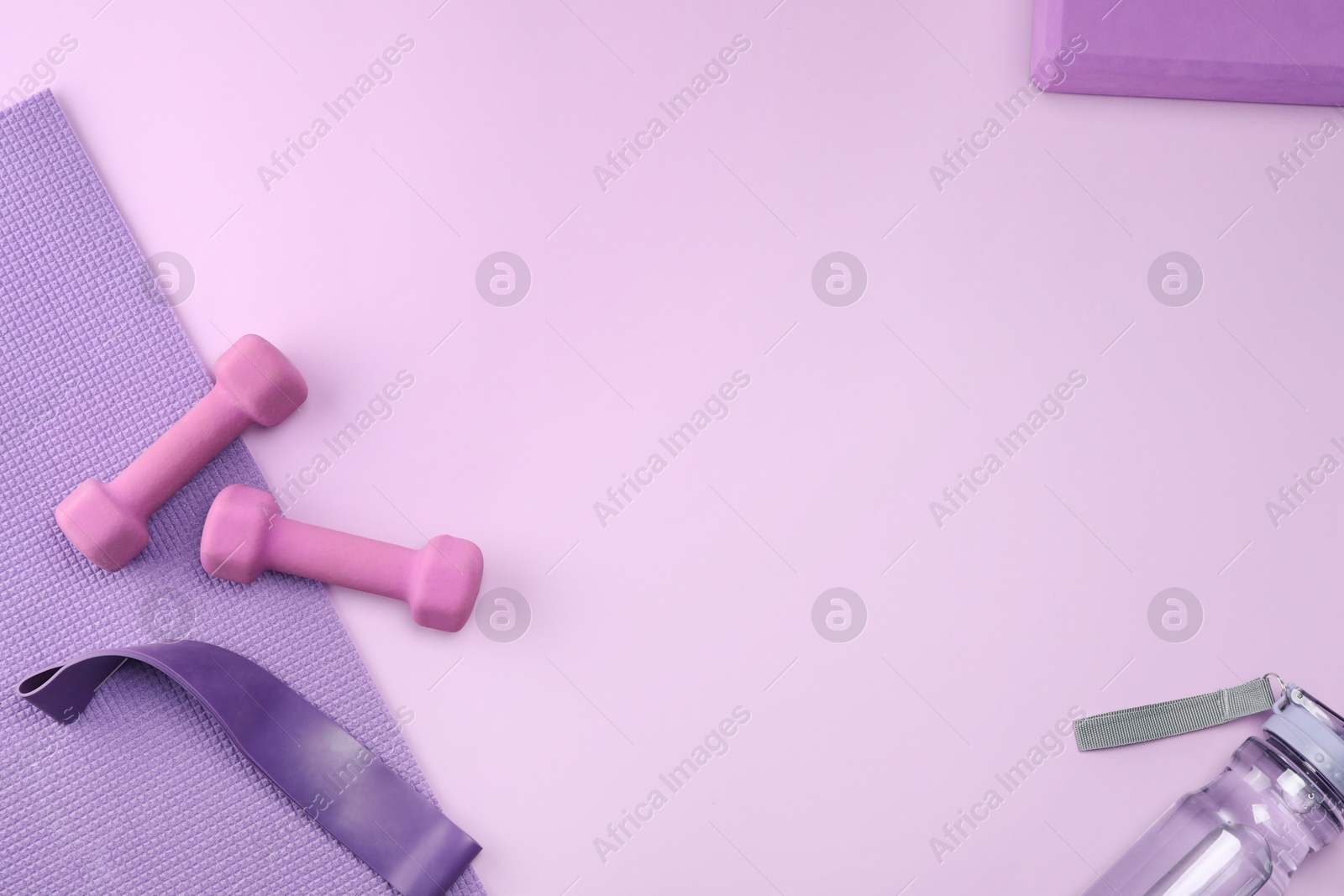 Photo of Two dumbbells, yoga mat, fitness elastic band and bottle on violet background, flat lay. Space for text