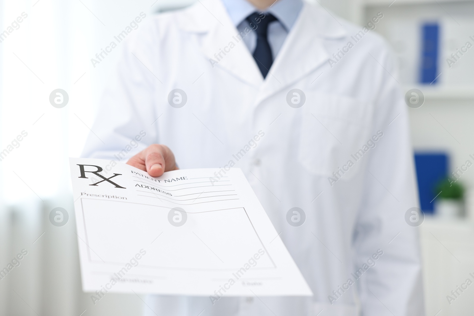 Photo of Doctor with blank prescription form in clinic, closeup