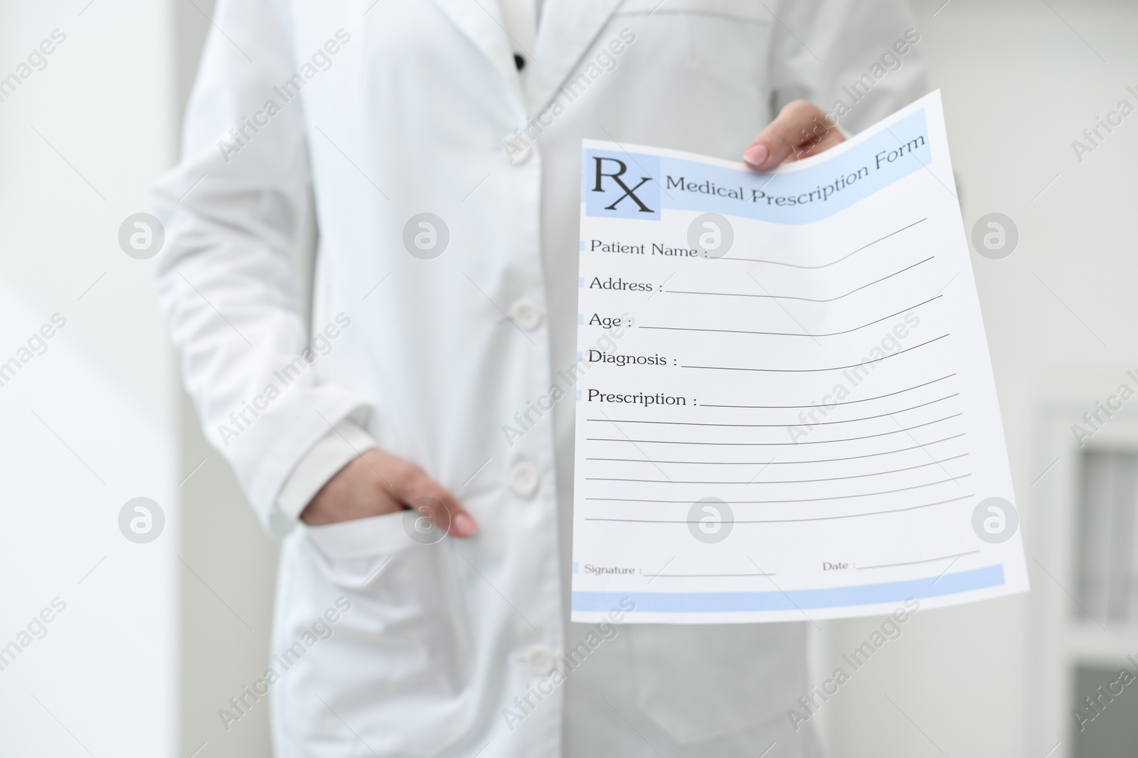 Photo of Doctor with blank prescription form in clinic, closeup