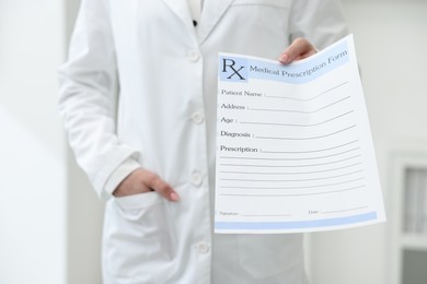 Photo of Doctor with blank prescription form in clinic, closeup