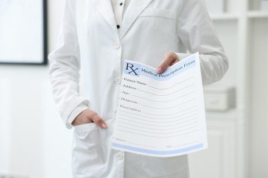 Photo of Doctor with blank prescription form in clinic, closeup