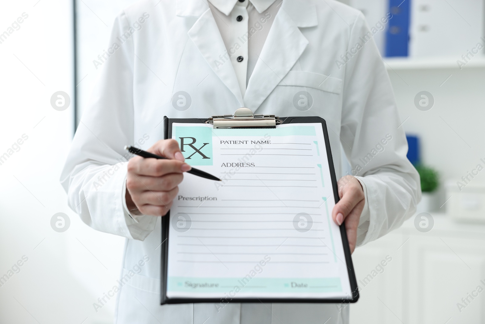 Photo of Doctor with blank prescription form in clinic, closeup