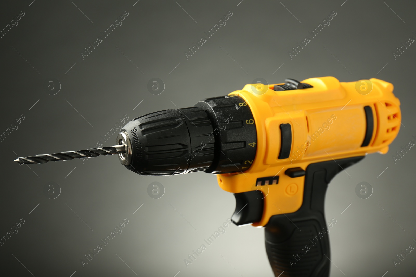 Photo of Modern cordless electric drill on grey background, closeup