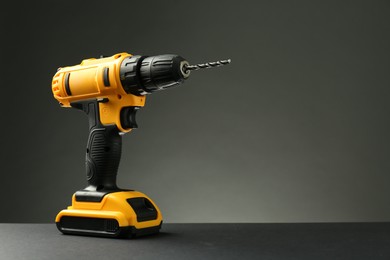 Modern cordless electric drill on grey background. Space for text