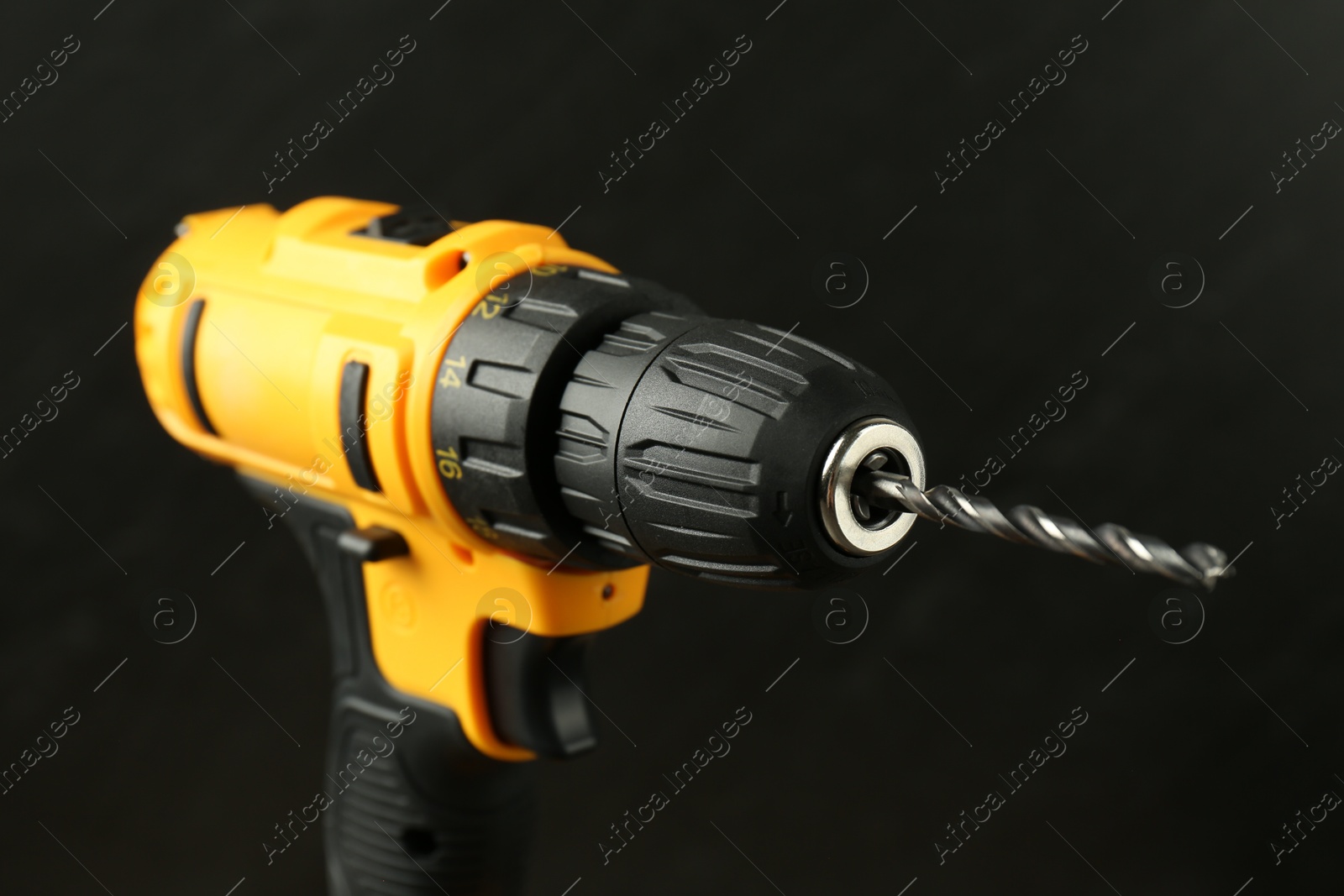 Photo of Modern cordless electric drill on black background, closeup