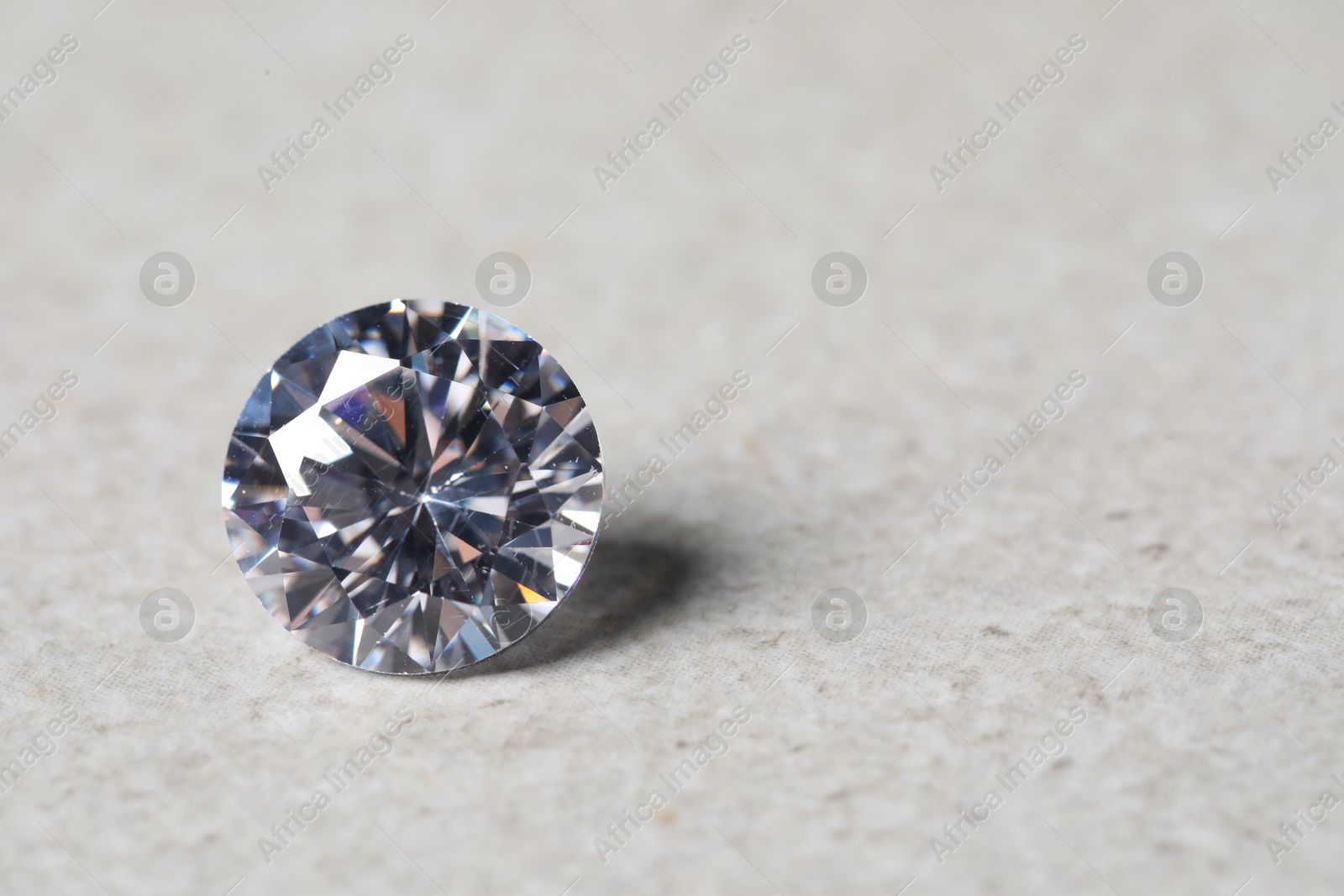 Photo of One beautiful shiny diamond on light background, closeup. Space for text