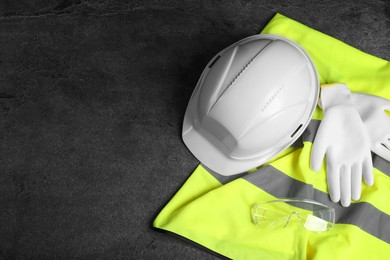 Photo of Reflective vest, hard hat, protective gloves and goggles on gray background, flat lay. Space for text