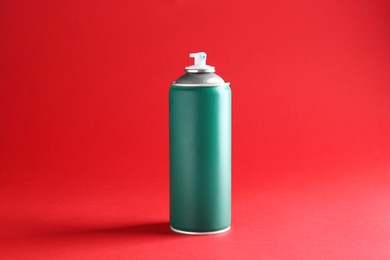 Photo of One green spray paint can on red background